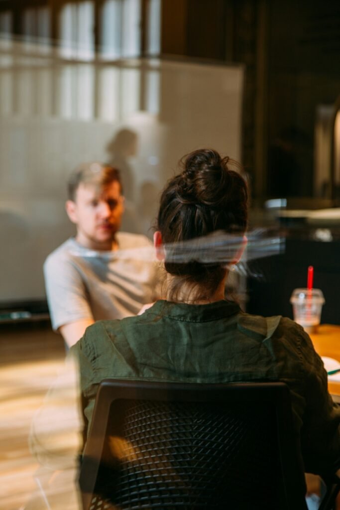 Confidential family coaching conversation viewed through a window reflection at New York Interventionist