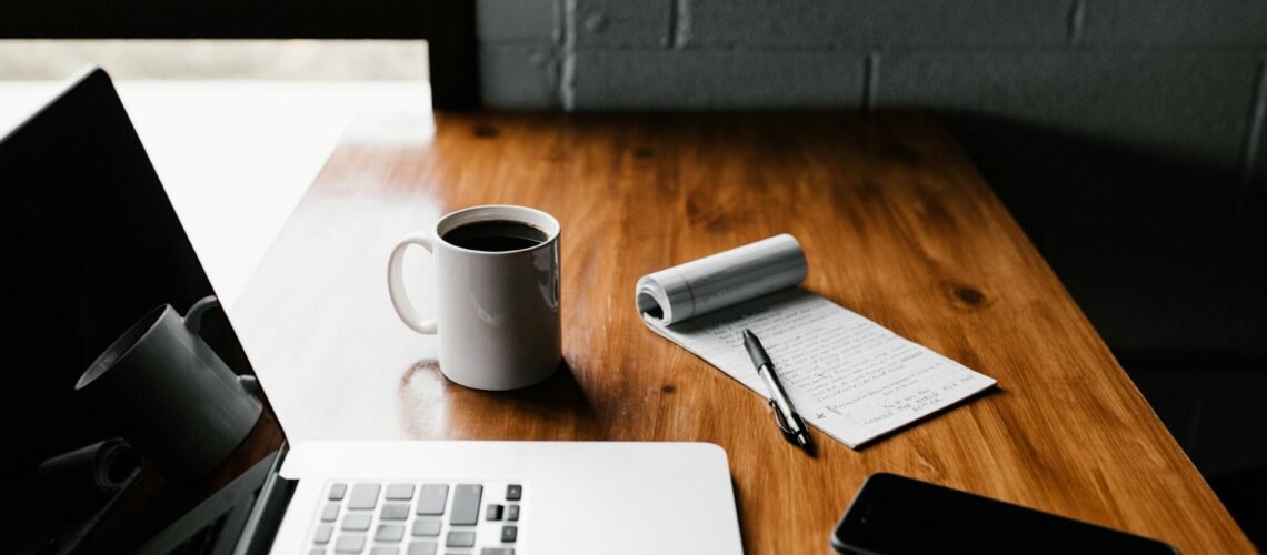 Notepad, pen, and coffee on a wooden desk prepared for a focused hourly consulting session in New York