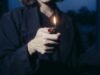 Hand holding a lit lighter at dusk, the flame illuminating the quiet, often-hidden moments of cannabis dependence.